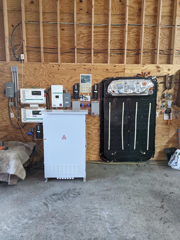 Closed cabinet next to a wall-mounted Tesla pack