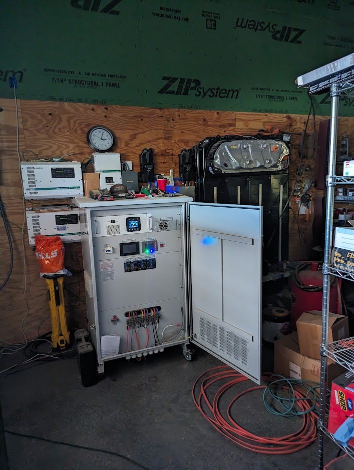 Cabinet running in a workshop next to a Tesla pack